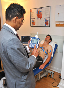 A photo of Dr Malik performing ECG on a patient